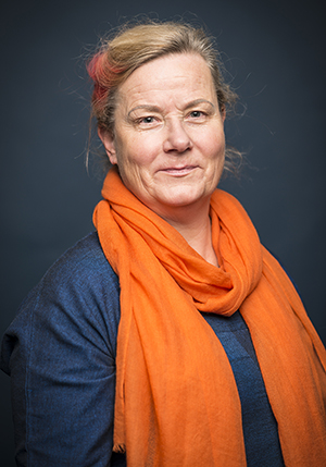 Porträttfoto i studio på Eva Holmberg Tedert med orange sjal virat runt halsen.