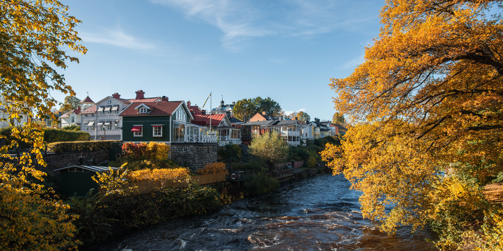 Gavleån med orangea löv på höger sida och villor på vänster sida