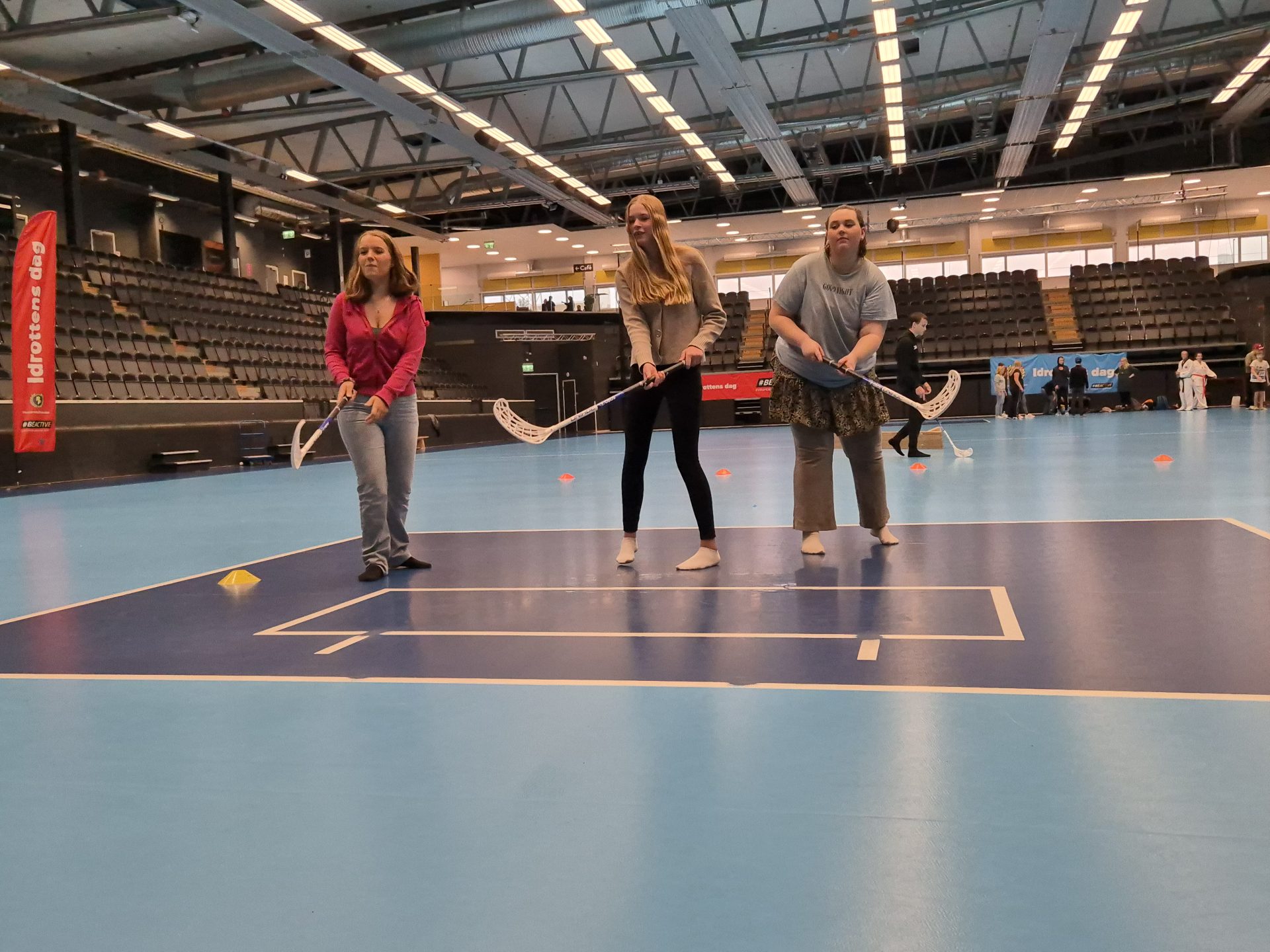 Tre tjejer som spelar innebandy.