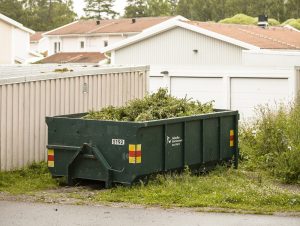 Avfallscontainer framför hus.