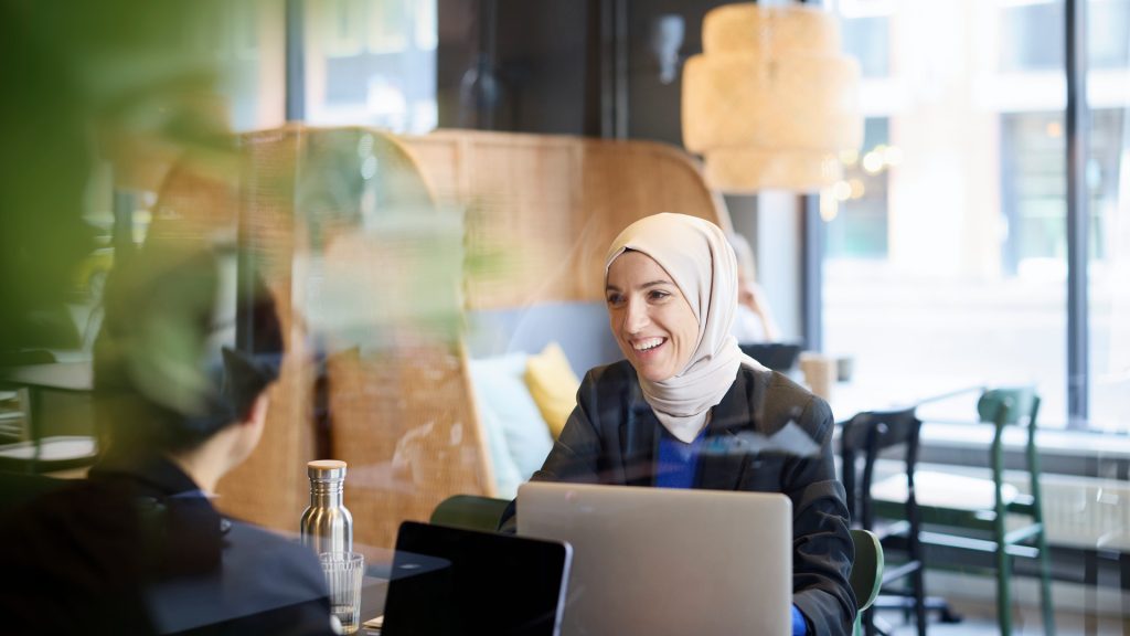 Två kvinnor jobbar med dator på kafé