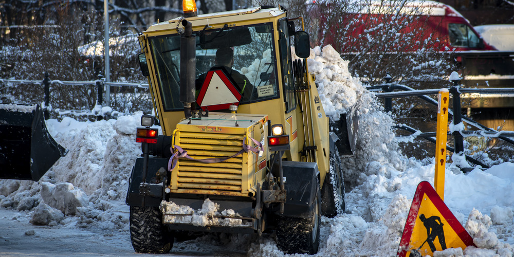 En traktor som skyfflar bort snö.