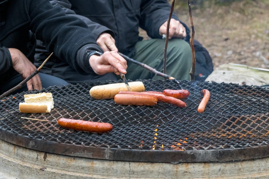 Grillar korv på en betonggrill